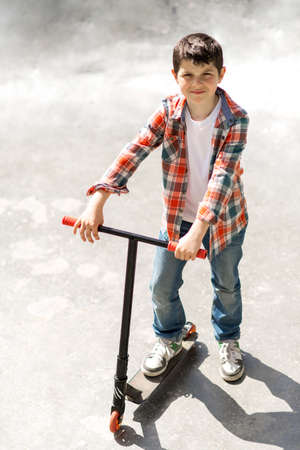 Cute boy hands holding the steering wheel of a scooter