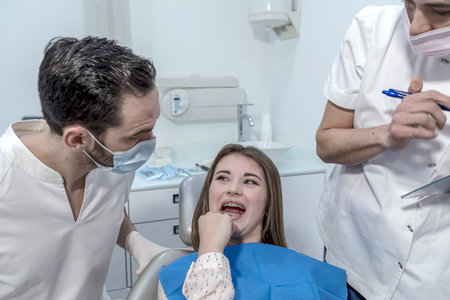 Teen female with toothache pain sitting to dental chair during teeth examination