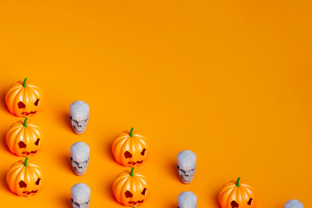 3d render of Halloween pumpkin and white skull covering half of the orange backgroundの写真素材