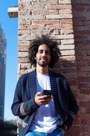 Afro man using mobile phone on street.の写真素材