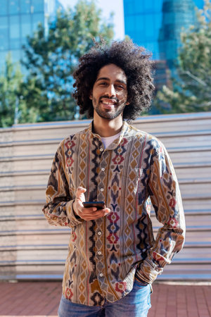 Afro man using mobile phone on street.