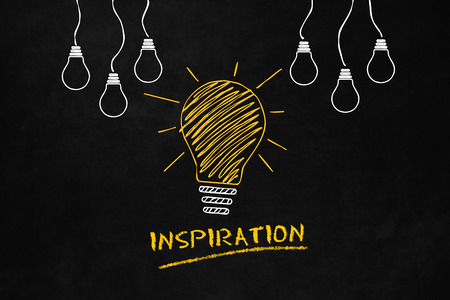 An inspiration metaphor with a Lightbulb on a blackboard, A conceptual design of a inspirational idea, A Big Yellow Light Bulb with 6 smaller white light bulbs and Text "Inspiration"の写真素材