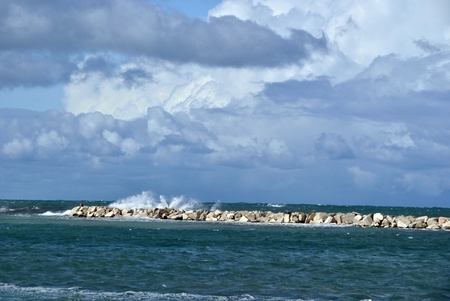 windy day at sea with big waves against rocksの写真素材