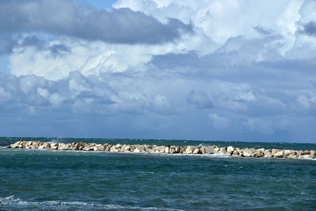 windy day at sea with big waves against rocksの写真素材