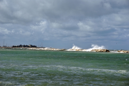 windy day at sea with big waves against rocksの写真素材