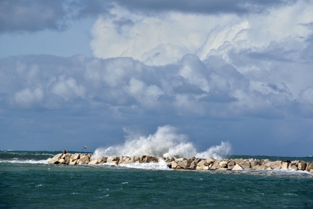 windy day at sea with big waves against rocksの写真素材