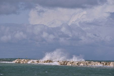 windy day at sea with big waves against rocksの写真素材
