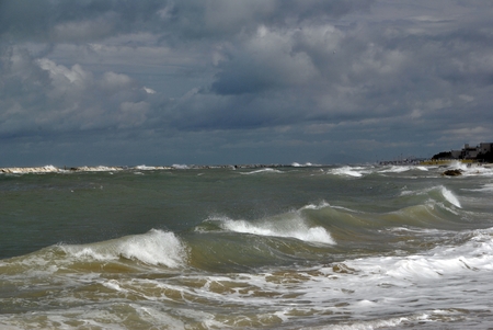 windy day at sea with big waves against rocksの写真素材