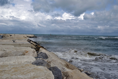windy day at sea with big waves against rocksの写真素材