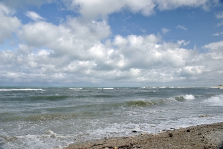 windy day at sea with big waves against rocksの写真素材