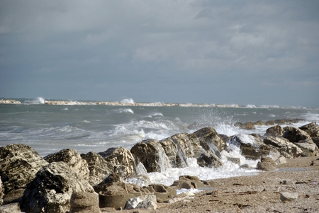 windy day at sea with big waves against rocksの写真素材