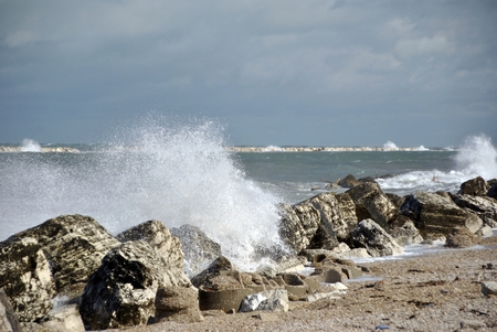 windy day at sea with big waves against rocksの写真素材