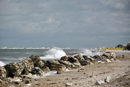 windy day at sea with big waves against rocksの写真素材
