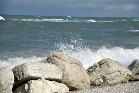 windy day at sea with big waves against rocksの写真素材