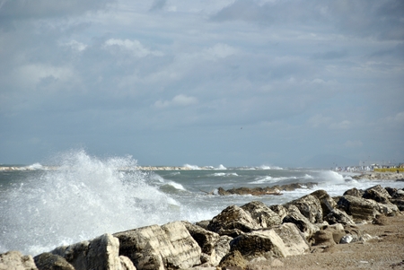 windy day at sea with big waves against rocksの写真素材