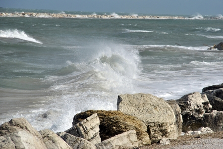 windy day at sea with big waves against rocksの写真素材
