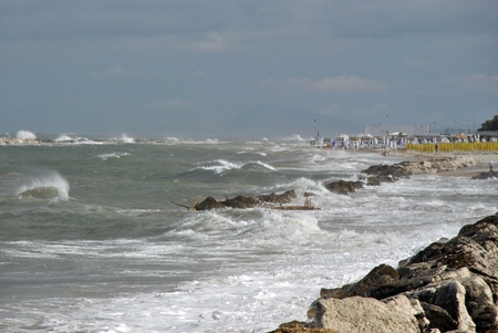 windy day at sea with big waves against rocksの写真素材