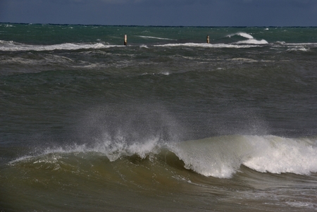 windy day at sea with big waves against rocksの写真素材