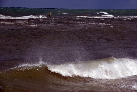 windy day at sea with big waves against rocksの写真素材