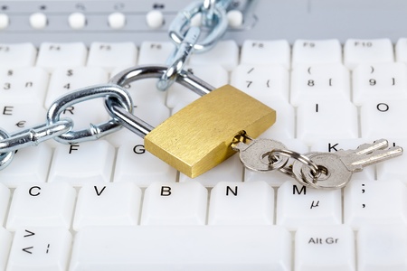 Computer keyboard with silver chain, padlock and keys relating to computer security or parental...