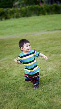 little child wear casual suit playing in the park. Portrait of  little kid running in the playground with smiling face. Happy Family Concept.の写真素材
