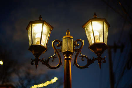 Old vintage street lamp on the road at night. Old vintage streetlight on dark night.の写真素材