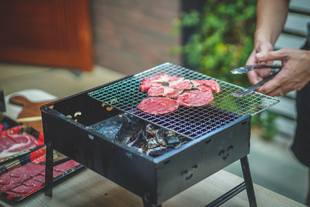Multiple sliced meats is grilling  on charcoal grill during summer time. Hot Fire Charcoal Grill. BBQ party at home outdoors. Premium raw red beef.の写真素材