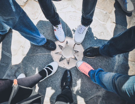 People gather outside building for Milan Women's Fashion Week  in Milan. Friends with stack of legs showing unity and teamwork. Team Teamwork Togetherness Collaboration Conceptの写真素材
