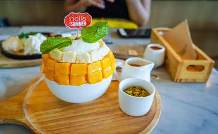 Mango ice cream with whipped cream topping in white bowl, Thailand.の写真素材