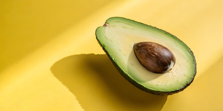 Fresh avocado half glistens under sunlight, offering healthy eating and vibrant wellness concepts