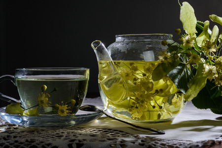 Linden flowers in  transparent teapot at dark backgroundの写真素材