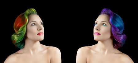 Portrait of young woman with vibrant multi colored hair on black backgroundの写真素材