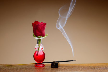 Small bottle with red liquid and red rose as the capの写真素材