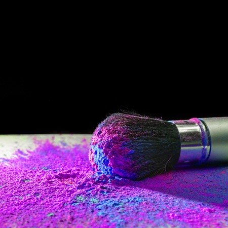 Makeup brush covered with bright holi dry powder paintの写真素材