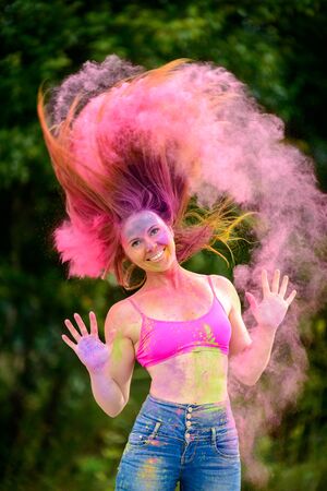 Young cheerful woman at Holi paint party