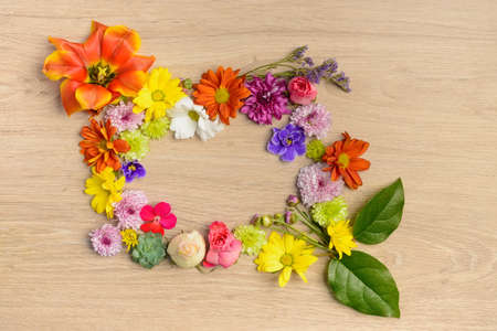 Different single flowers scattered on wooden tableの写真素材