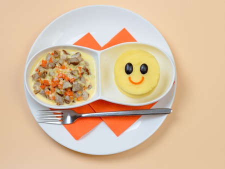 Mashed potatoes and stew arranged as funny breakfast for kidsの写真素材