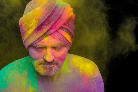 Senior man in traditional Indian turban fully covered with paint holiの写真素材