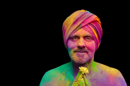 Senior man in traditional Indian turban fully covered with paint holiの写真素材