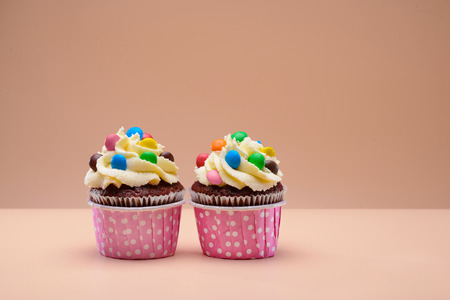 Colorful muffins decorated with round candies on themの写真素材