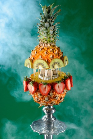 Smoking hookah with fruit head on dark backgroundの写真素材