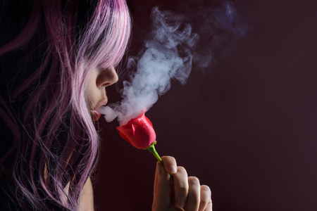 Portrait of girl with pink long hair smokingの写真素材