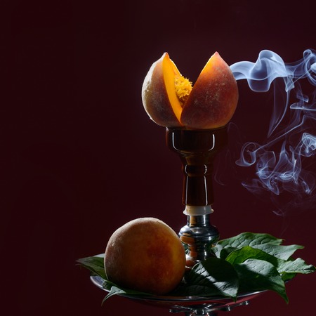 Smoking hookah with fruit head on dark backgroundの写真素材