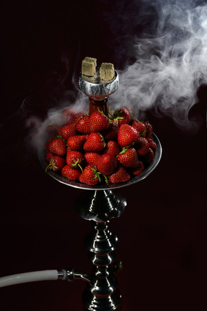 Smoking hookah with fruit head on dark backgroundの写真素材