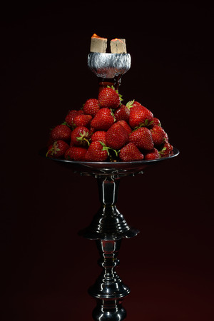 Smoking hookah with fruit head on dark backgroundの写真素材
