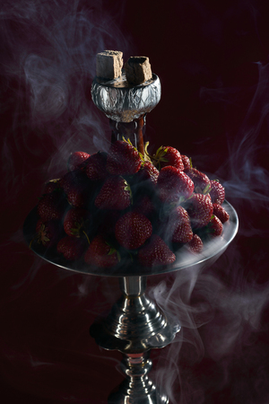 Smoking hookah with fruit head on dark backgroundの写真素材