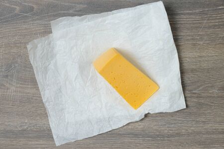 Triangle cut of cheese on wooden table useful for food design