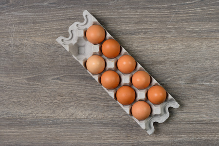 Brown eggs in separate tray on wooden table