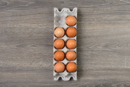 Brown eggs in separate tray on wooden table