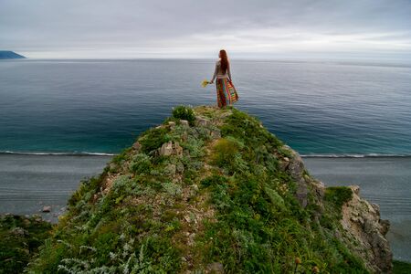 Long-haired girl walking on sea shore in springtimeの写真素材